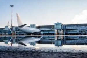 passenger-aircraft-parked-jetway-with-reflection-puddle-min