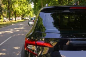 Back,Window,Of,Black,Car,Parked,On,The,Street,In