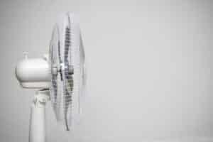 Floor fan standing on a gray wall background